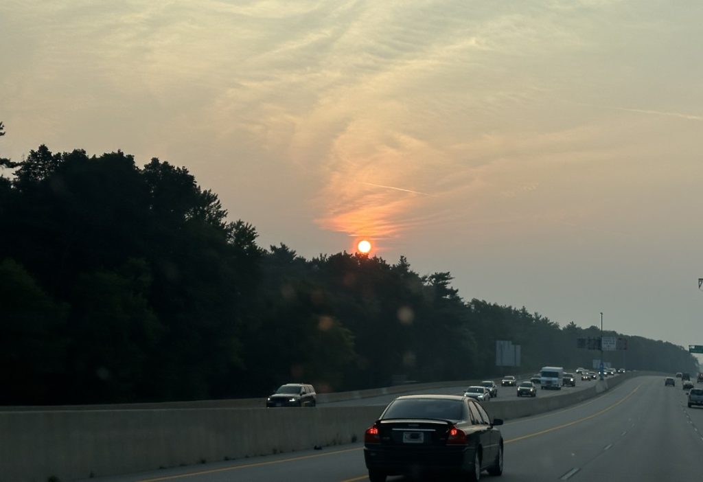 A photo of a smoky sunset seen from a highway